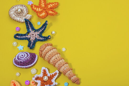 Summer crocheting concept. Handmade coral reef, marine style, underwater animals, yellow background