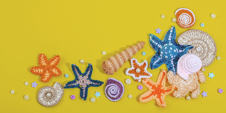 Summer crocheting concept. Handmade coral reef, marine style, underwater animals, yellow background
