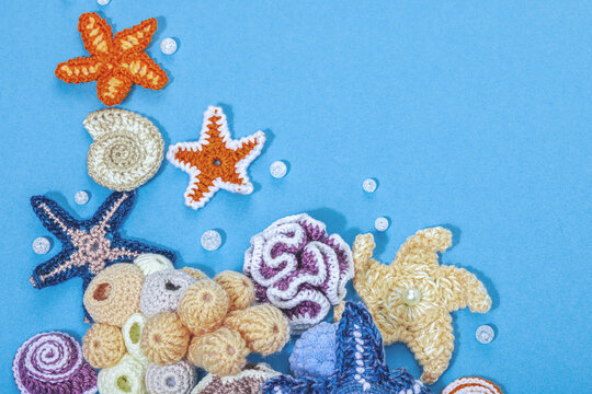 Summer crocheting concept. Handmade coral reef, marine style, underwater animals, blue background