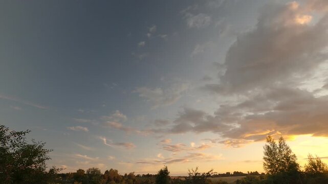 Dramatic Summer Sunset With Golden Orange Sky and Fast Moving Dark Clouds Across the Horizon, Evening Weather Timelapse