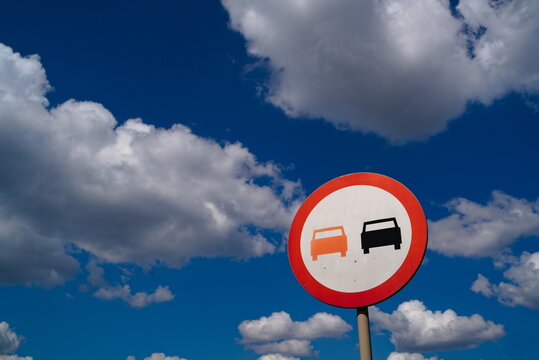 No overtaking road sign against dramatic blue cloudy sky background.
