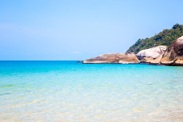 A scenic stone cliff frames a beautiful calm turquoise bay with white sand on Koh Phangan. Tropical Thailand vacation coast landscape view, beach getaway backdrop. © Natalia