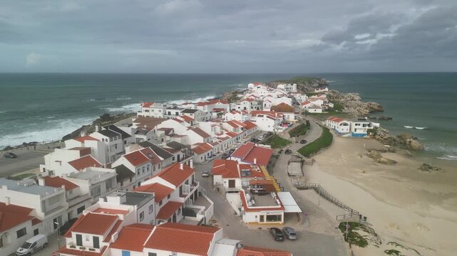 Aerial view of Baleal Island with white houses and red roofs along the sandy coastline in Peniche, Leiria District, Portugal.