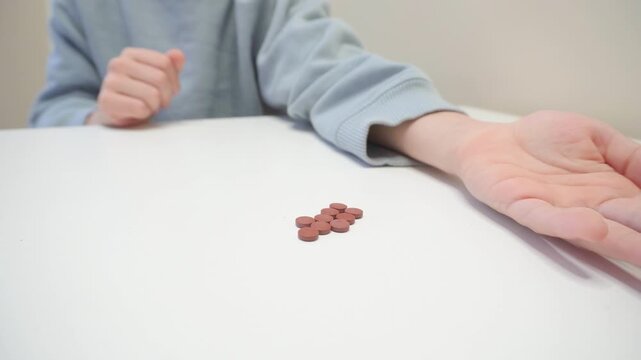A child hiding pills. Topics related to medicine, pharmacy, responsible use of medicines, health, and proper medication management.