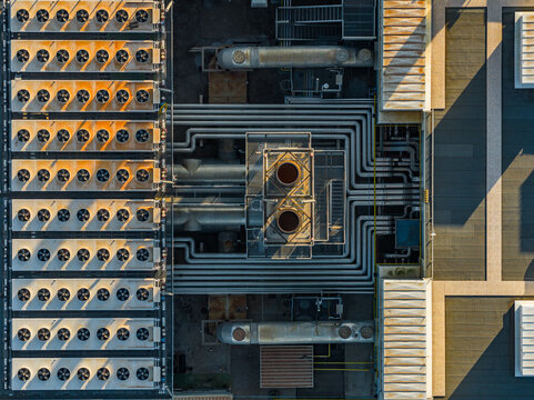 Aerial view of the Acea water treatment plant featuring rows of industrial cooling fans, complex piping systems, and ventilation units on a rooftop in Roma, Lazio, Italy.