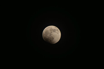 Moon experiencing a partial lunar eclipse, earth's shadow slowly obscuring its illuminated surface, highlighting the celestial dance and astronomical wonder in space © VICTOR A ARGUELLO
