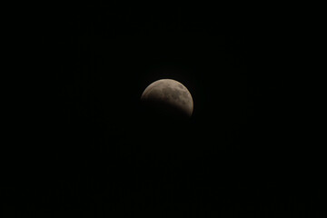 Partially eclipsed full moon creating a celestial spectacle against a dark night sky, symbolizing mystery, the cosmos, and natural astronomical phenomena © VICTOR A ARGUELLO