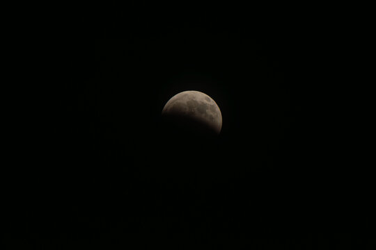 Partially eclipsed full moon creating a celestial spectacle against a dark night sky, symbolizing mystery, the cosmos, and natural astronomical phenomena