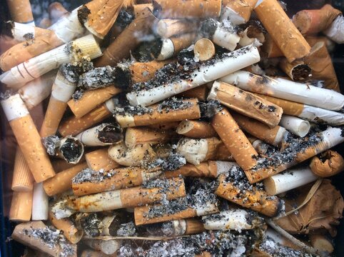 View from above on many cigarette butts in ashtray