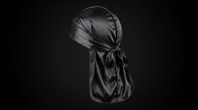 A black silk durag headwrap displayed on a plain dark background for fashion accessory presentation with headwrap shown isolated isolated against solid black satin