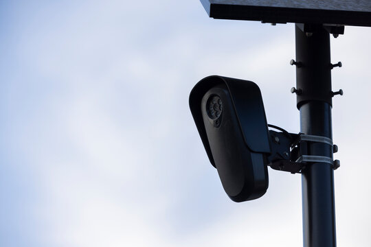 An Artificial Intelligence AI Camera surveils a city street for car license plates.