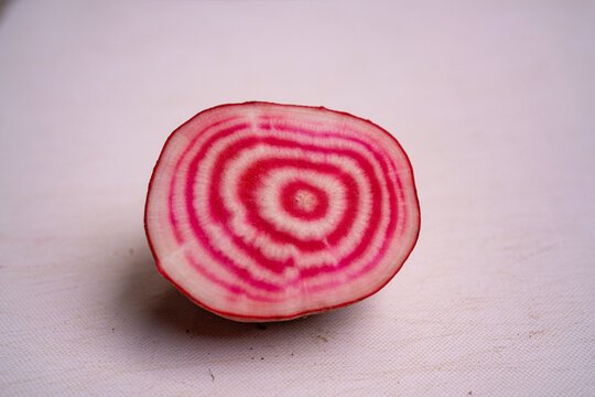 Cross section of a chioggia beetroot showing concentric pink rings on white