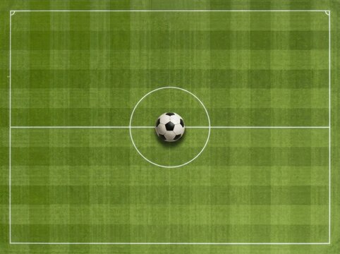 Aerial view of soccer ball on center of green football field pitch with perfect markings
