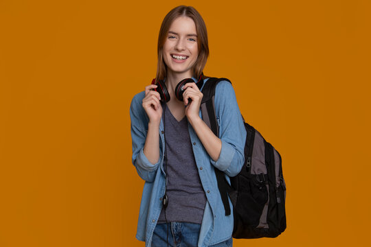 Happy college student with backpack and headphones