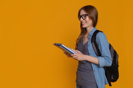 College student carrying books and backpack beside copy space