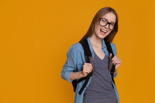 Cheerful college student with backpack beside copy space