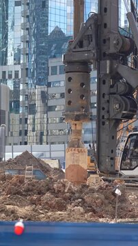 Heavy piling rig standing at a large urban construction site, representing bored pile foundation engineering, site preparation, geotechnical construction and major property development