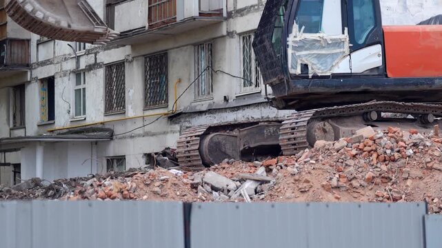 Heavy excavator working among brick and concrete rubble during building demolition, capturing urban redevelopment, site clearance and structural removal
