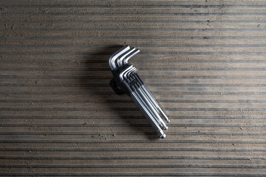 hex key set resting metallic grid patterned surface top-down perspective neutral utilitarian home improvement mechanical tools diy projects silver black plastic case.