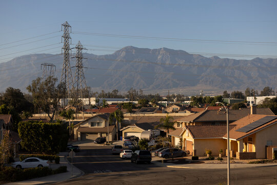 Afternoon sun shines on single family homes and industry  in the Declezville neighborhood of Fontana, California, USA.