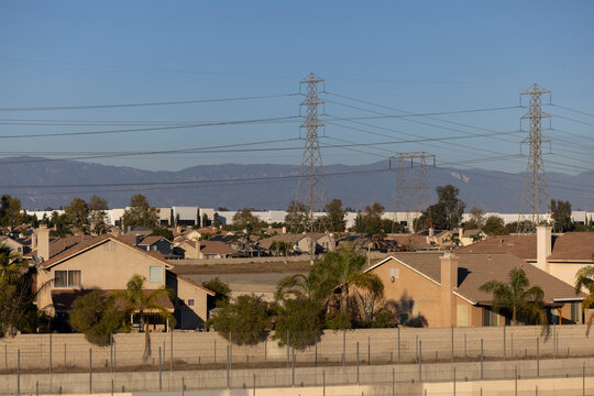 Afternoon sun shines on single family homes and industry  in the Declezville neighborhood of Fontana, California, USA.