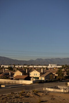 Afternoon sun shines on single family homes and industry  in the Declezville neighborhood of Fontana, California, USA.