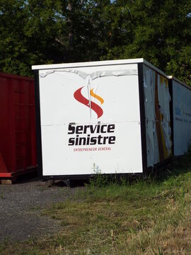 Gatineau, Quebec, Canada &ndash; June 30, 2026: A white "Service Sinistre" storage container with a red and orange logo sits outdoors on a gravel lot on Bd Saint-Ren&eacute; E.