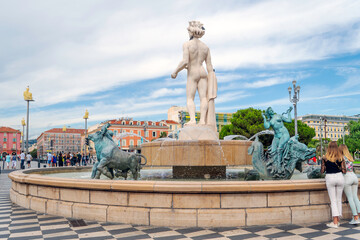 Fototapeta premium The Fontaine du Soleil Sun Fountain featuring a 23' white marble statue of Greek god Apollo, a prominent landmark located in Place Masséna in the heart of Nice, France.