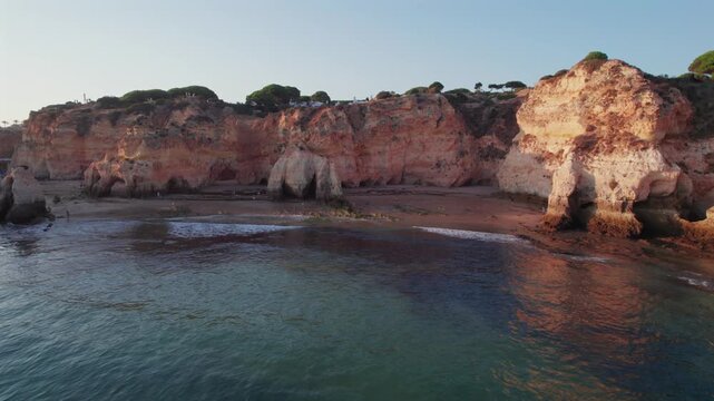 Aerial view of the beautiful Praia dos Tres Irmaos rocky coast in Alvor, Algarve. Picturesque coastline of Portugal with stunning caves