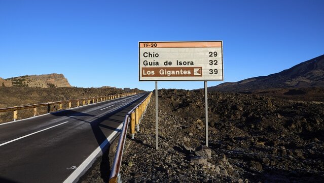 Signpost on a deserted road under blue sky in a mountain landscape, Teide, Parque Nacional del Teide, Teide National Park, volcano, volcanism, UNESCO World Heritage Site, Tenerife, Canary Islands, Spain
