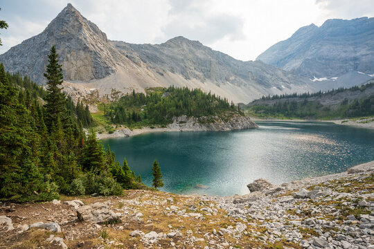 Lower Galatea Lake rugged alpine scenery with deep blue waters and towering rocky slopes. Kananaskis, Alberta, Canada.