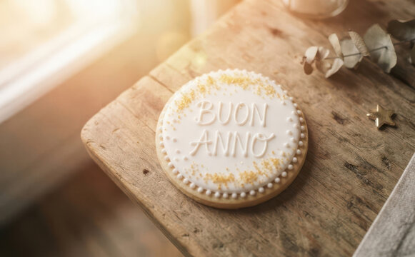 Decorated New Year cookie with Buon Anno text on a rustic wooden table for a festive Italian holiday celebration concept