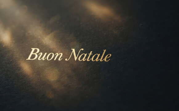 Elegant golden Buon Natale greeting text embossed on dark textured paper background for luxury Christmas holiday design and seasonal celebration concepts
