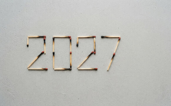 Year 2027 spelled out using wooden matches on a concrete background representing future planning and time concept