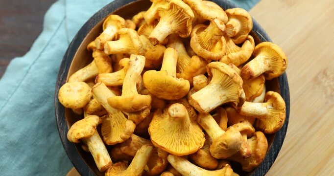 Golden chanterelle mushrooms in bowl on table, top view