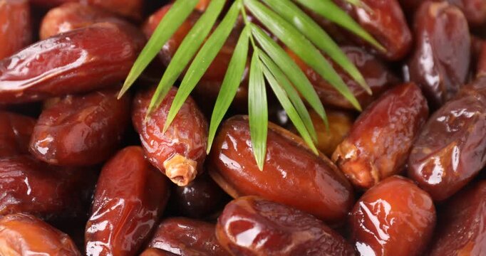 Tasty dried dates and palm leaf turning, closeup