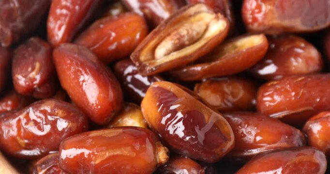 Bowl with tasty dried dates turning, closeup