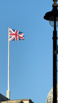 British Union Jack flag waving against clear blue sky