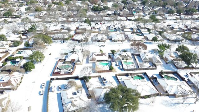 Private residential properties line Heartz Road corridor across northern DFW suburbs. Turquoise swimming pools punctuate snowdrifts covering neighborhood lawns throughout Coppell, Texas