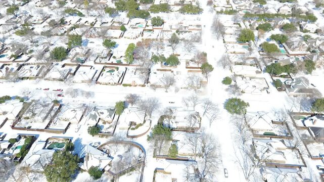Housing developments extend along Moore Road corridor throughout suburban DFW area. High winter snow accumulation blankets neighborhood grids, driveways, rooftops in Coppell, Texas