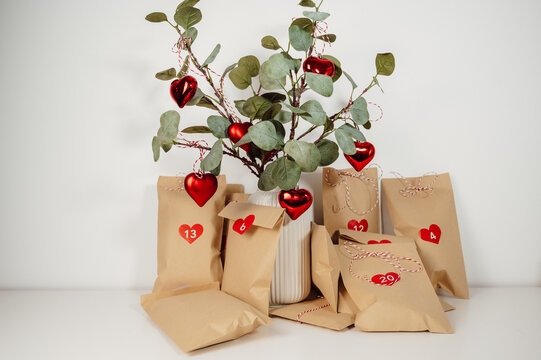 Advent calendar bags with numbers near eucalyptus christmas tree. winter traditions,alternative christmas tree