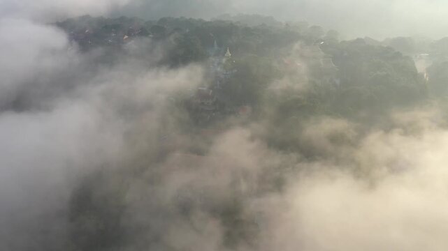 Aerial drone view of Tuyen Lam Lake at sunrise, seen from the dam in Xuan Huong, Da Lat, Lam Dong, Vietnam, with morning mist, pine forests and rolling mountains.
