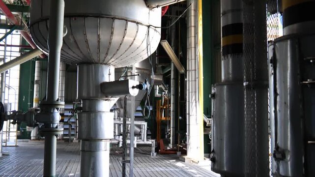 Complex oil and chemical processing facility with dense pipe networks, industrial valves, machinery, and structural engineering elements, representing energy production, process automation, industrial
