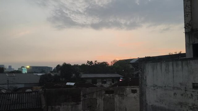 Soft orange glow on the horizon during late afternoon sunset behind urban houses