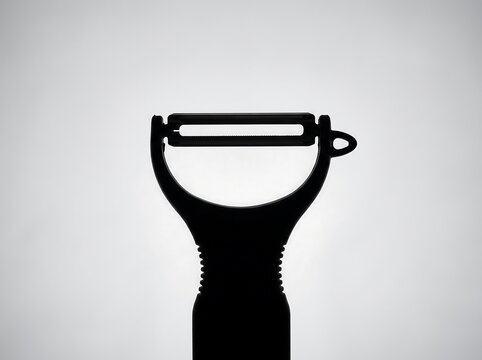Silhouette of a vegetable peeler against a white background