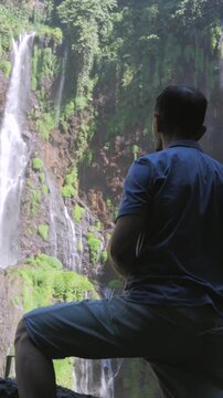 Hiker admiring the tumpak sewu waterfall in indonesia