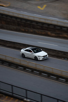 High-Angle View of a White Mercedes-Benz CLA Driving on an Urban Highway