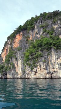 Sailing past tropical limestone cliff islands