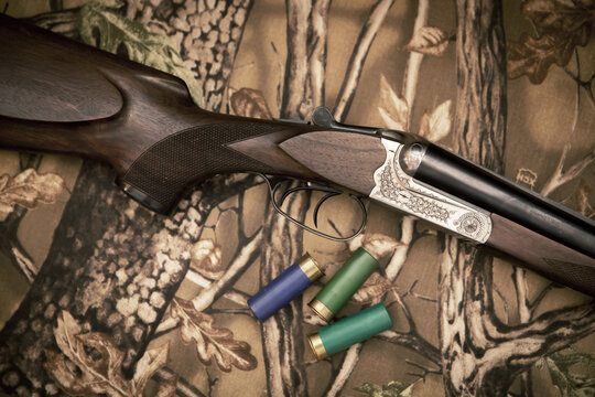 A wooden retro shotgun with shotgun shells