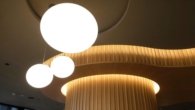 Modern interior lighting with spherical hanging lamps and wooden ceiling architecture